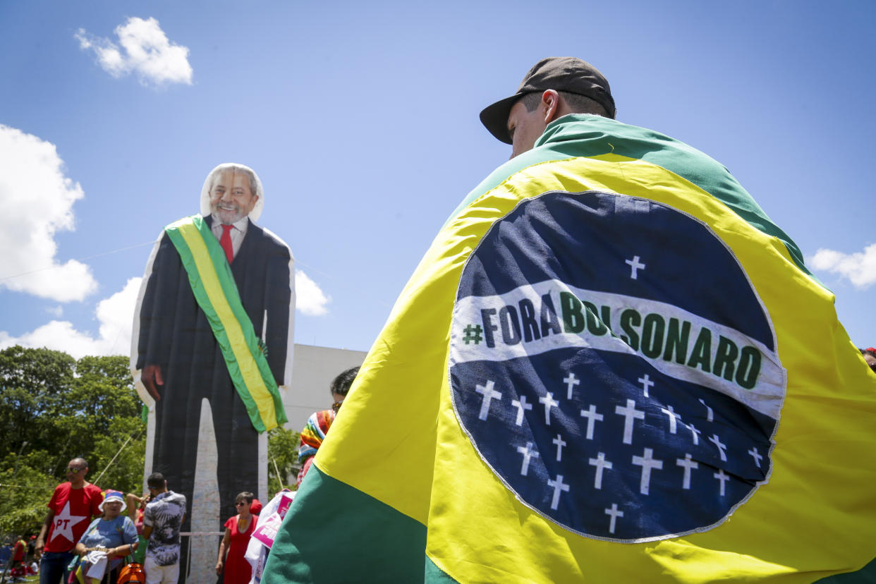 A man carries a flag reading in Portuguese "Bolsonaro Out¨ prior to the inauguration of Luiz Inacio Lula da Silva as new president in Brasilia, Brazil, Sunday, Jan. 1, 2023. (AP Photo/Gustavo Moreno)