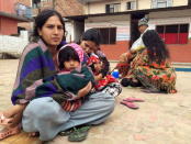 People wait at a school after a 7.7 magnitude earthquake struck, in Kathmandu, Nepal, April 25, 2015.