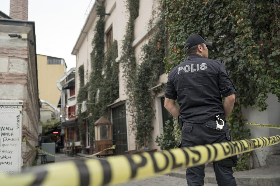 A police officer stands at the site after former British army officer who helped found the "White Helmets" volunteer organization in Syria, James Le Mesurier's body was found in Istanbul, Turkey, Monday Nov. 11, 2019. Turkish officials and news reports said Monday that Le Mesurier's body was found near his home in Istanbul's Beyoglu district.(AP Photo/Emrah Gurel)