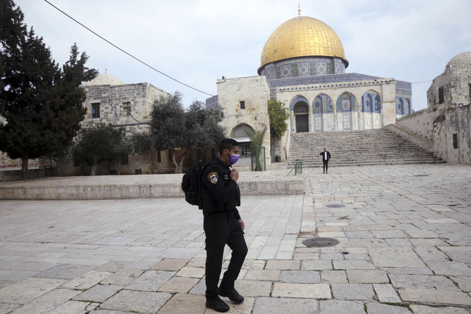 Israeli policeman walks in front of the Dome of the Rock in Jerusalem, Sunday, March 15, 2020. Israel imposed sweeping travel and quarantine measures more than a week ago but has seen its number of confirmed coronavirus cases double in recent days, to around 200. On Saturday, the government said restaurants, malls, cinemas, gyms and daycare centers would close. (AP Photo/Mahmoud Illean)