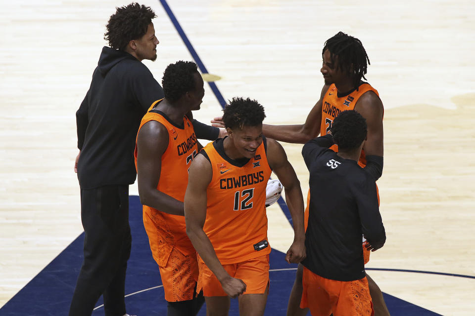 Oklahoma State players celebrate after defeating West Virginia in an NCAA college basketball game Saturday, March 6, 2021, in Morgantown, W.Va. (AP Photo/Kathleen Batten)