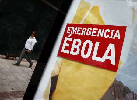 An advertisement for donations to fight Ebola in Africa is displayed on a bus stop near the apartment building of the nurse who contracted Ebola, in Alcorcon, outside Madrid, October 8, 2014. REUTERS/Sergio Perez