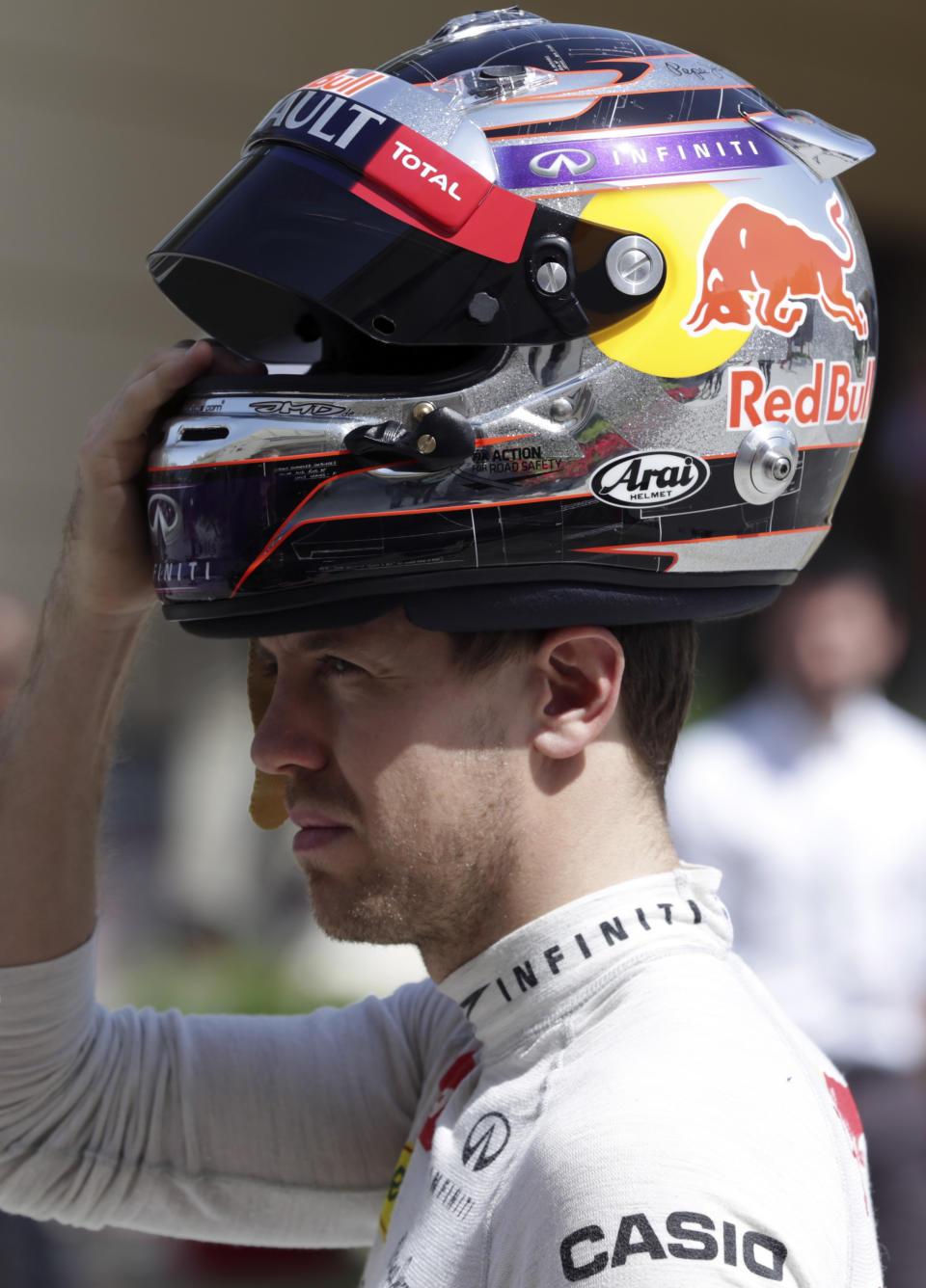 Formula One driver Sebastian Vettel of Red Bull Racing holds his helmet in the paddock after breaking down during pre-season testing at the Bahrain International Circuit in Sakhir, Bahrain, Satuday, March 1, 2014. (AP Photo/Hasan Jamali)
