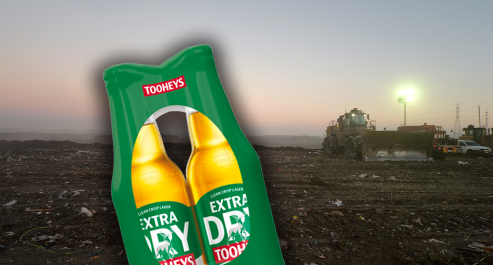 Foreground - a Tooheys Extra Dry six pack. Background - a landfill facility.