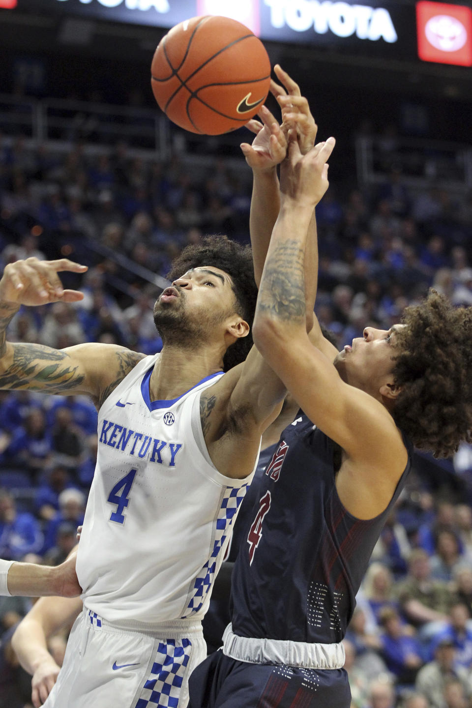 Kentucky's Nick Richards, left, and Fairleigh Dickinson's Brandon Powell, right, battle for a rebound during the first half of an NCAA college basketball game in Lexington, Ky., Saturday, Dec. 7, 2019. (AP Photo/James Crisp)