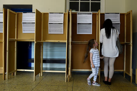 A woman casts her vote with her daughter in a polling station on the day of the Abortion Referendum on liberalising abortion laws in Dublin, Ireland May 25, 2018. REUTERS/Clodagh Kilcoyne