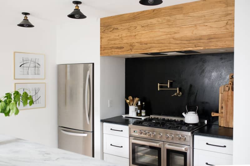 a black and white industrial kitchen with wood accents