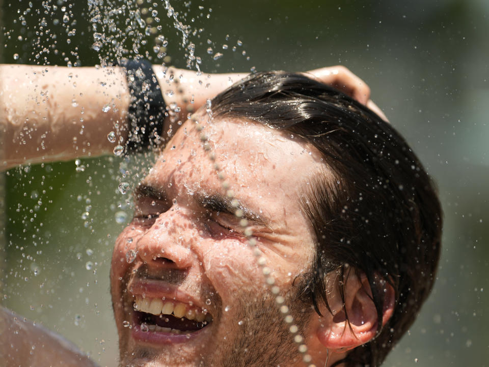 Lifeguard Callum Glover cools off during a safety break at the Memorial Park swimming pool on Wednesday, June 28, 2023, in Houston. There is a 10-minute safety break each hour in which swimmers must exit the pool, and lifeguards take a break and rotate then their stations. (Melissa Phillip/Houston Chronicle via AP)