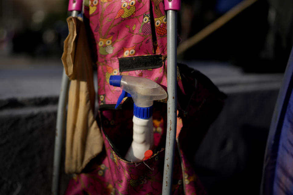 Un bote con espray desinfectante, junto a un baño seco improvisado dentro de una tienda de campaña, en una plaza durante una protesta antigubernamental en Buenos Aires, Argentina, el 6 de junio de 2024. Alejandra, una vendedora ambulante, observó que durante la protesta no había donde orinar y lanzó un negocio al amparo de las movilizaciones y de inflación descontrolada. Cobra la voluntad. (AP Foto/Natacha Pisarenko)