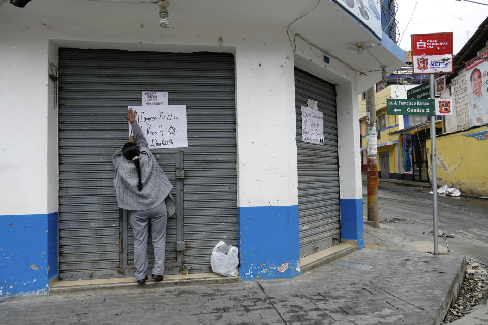 A person hangs a sign that reads in Spanish "He is Congress!" referring to ousted President Pedro Castillo the day after protests forced shops to shutter in Andahuaylas, Peru, Tuesday, Dec. 13, 2022. Castillo was detained on Dec. 7 after he was ousted by lawmakers when he sought to dissolve Congress ahead of an impeachment vote. (AP Photo/Franklin Briceno)