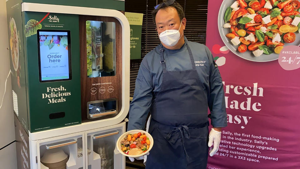 FILE - In this June 23, 2020 file photo, Kang Kuan, vice president of culinary at Chowbotics, holds a custom salad made by his company's robotic salad-making kiosk at the company's headquarters in Hayward, Calif. DoorDash is buying the automated food prep company to expand its fresh meal offerings. San Francisco-based DoorDash announced the acquisition Monday, Feb. 8, 2021. (AP Photo/Terry Chea, File)