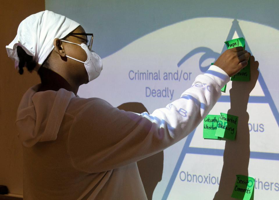 Jaiden Coleman, a freshman at Clark Montessori High School, takes part in a spectrum-of-violence activity during a Women Helping Women Prevent & Empower session on Sept. 23, 2021. Students were given sticky notes with scenarios and had to decide if the behavior was criminal, dangerous or obnoxious. The class teaches students about healthy relationships, what's not healthy, boundary-setting, consent and more. It is designed to prevent future gender-based violence.