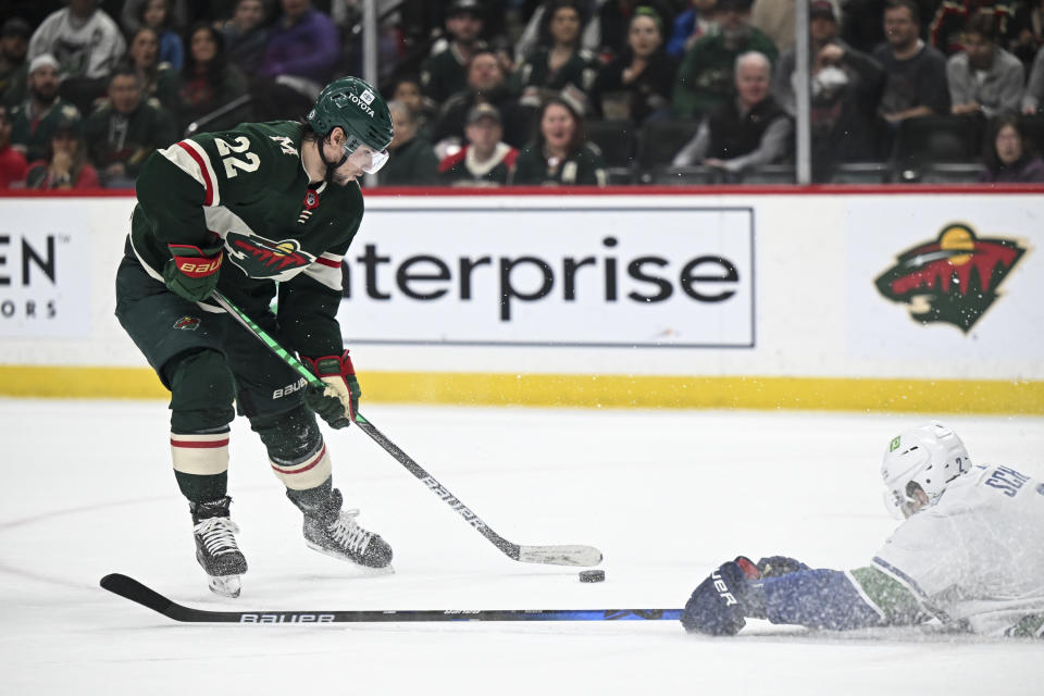 Vancouver Canucks defenseman Luke Schenn (2) slides to the ice to try to block a shot by Minnesota Wild left wing Kevin Fiala (22) during the first period of an NHL hockey game Thursday, April 21, 2022, in St. Paul, Minn. (Aaron Lavinsky/Star Tribune via AP)