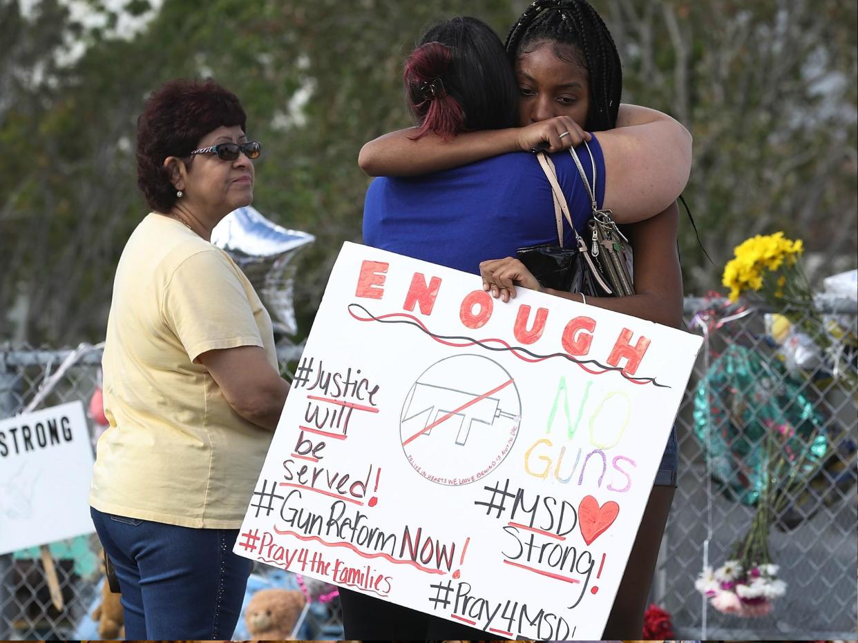 Tyra Heman, a senior at Marjory Stoneman Douglas High School, holds a sign that reads, 'Enough No Guns,' on 19 February 2018 in Parkland, Florida: Joe Raedle/Getty Images