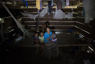 Claudia Maquin, 27, sits on a wooden bed while she answers questions from journalists with her three children, Elvis Radamel Aquiles Caal Maquin, 5, left, Abdel Johnatan Domingo Caal Maquin, 9, center, Angela Surely Mariela Caal Maquin, 6 months, right, in Raxruha, Guatemala, on Saturday, Dec. 15, 2018. Claudia Maquin's daughter, 7-year old Jakelin Amei Rosmery Caal, died in a Texas hospital, two days after being taken into custody by border patrol agents in a remote stretch of New Mexico desert. (AP Photo/Oliver de Ros)