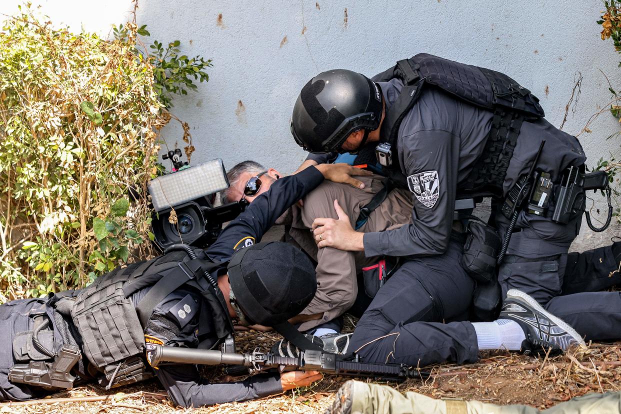 Israeli police and security forces assist a journalist taking cover during an alert for a rocket attack (AFP via Getty Images)
