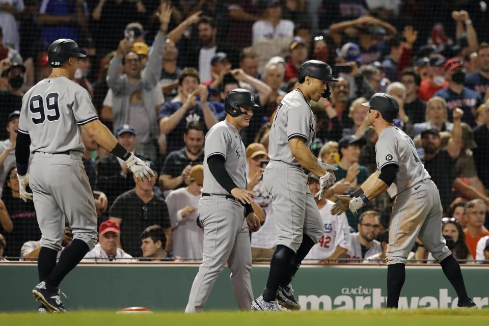 New York Yankees' Giancarlo Stanton, center, celebrates his grand slam that also drove in, from left, Aaron Judge, Anthony Rizzo and Brett Gardner during the eighth inning of a baseball game against the Boston Red Sox, Saturday, Sept. 25, 2021, in Boston. (AP Photo/Michael Dwyer)