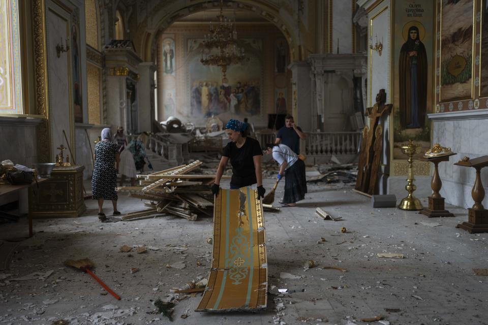 People clean up inside the Odesa Transfiguration Cathedral after it was heavily damaged in Russian missile attacks in Odesa, Ukraine, Sunday, July 23, 2023. (AP Photo/Jae C. Hong)