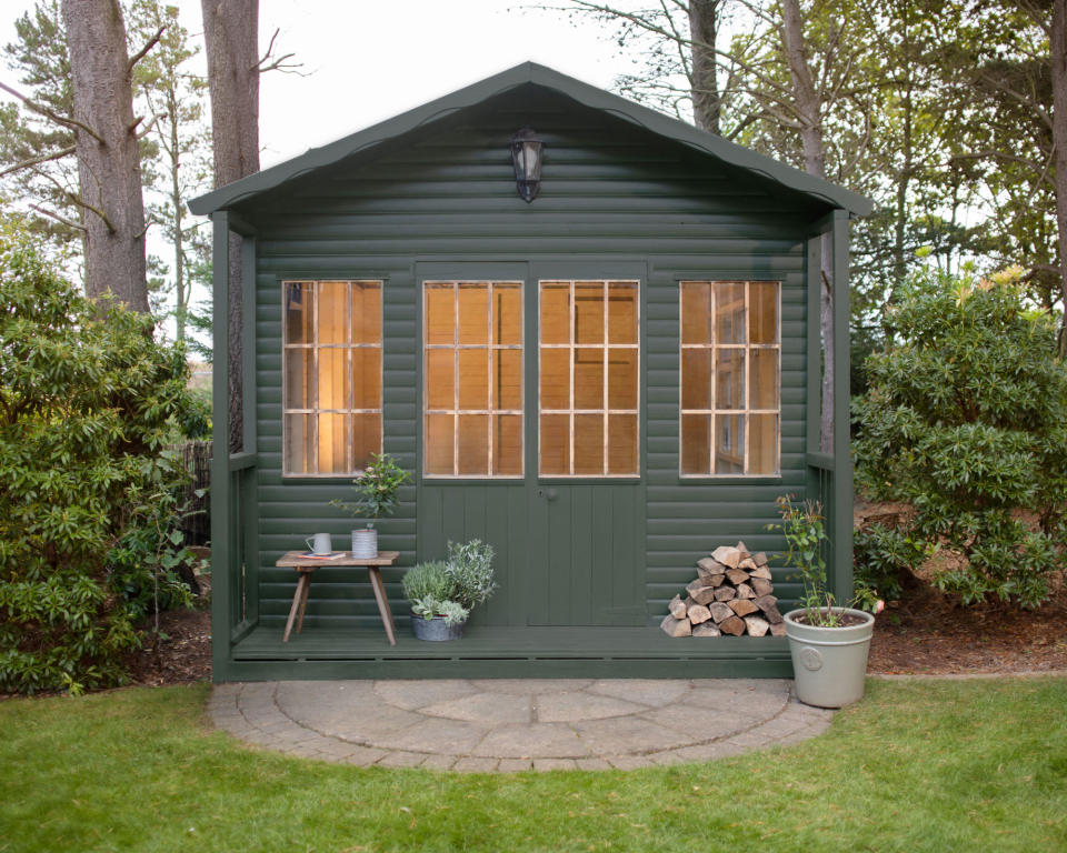 wooden shed painted green in autumn garden