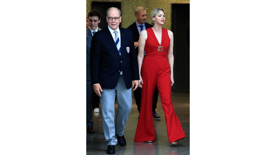 Prince's Albert and Princess Charlene in red jumpsuit walking