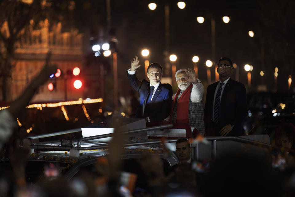 French President Emmanuel Macron, left, and Indian Prime Minister Narendra Modi greet people lining the streets as they ride an open vehicle together during a road show in Jaipur, Rajasthan, India, Thursday, Jan. 25, 2024. Macron will be the chief guest at India's annual republic day parade in New Delhi on Friday. (AP Photo/ Deepak Sharma)
