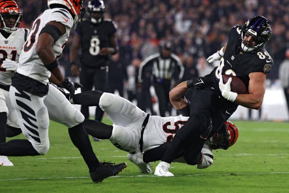 Mark Andrews #89 of the Baltimore Ravens is tackled by Logan Wilson #55 of the Cincinnati Bengals during the first quarter of the game at M&T Bank Stadium on November 16, 2023 in Baltimore, Maryland.