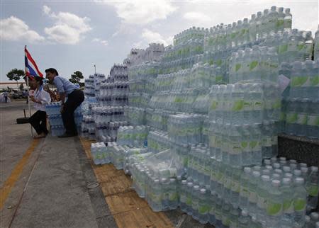 Anti-government protesters pose with stacks of bottled water during a rally at a government complex in Bangkok November 29, 2013. REUTERS/Chaiwat Subprasom