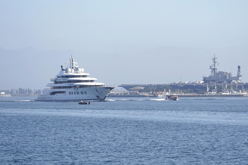 The super yacht Amadea passes the USS Midway Museum as it comes into the San Diego Bay Monday, June 27, 2022, seen from Coronado, Calif. The $325 million superyacht seized by the United States from a sanctioned Russian oligarch arrived in San Diego Bay on Monday. (AP Photo/Gregory Bull)