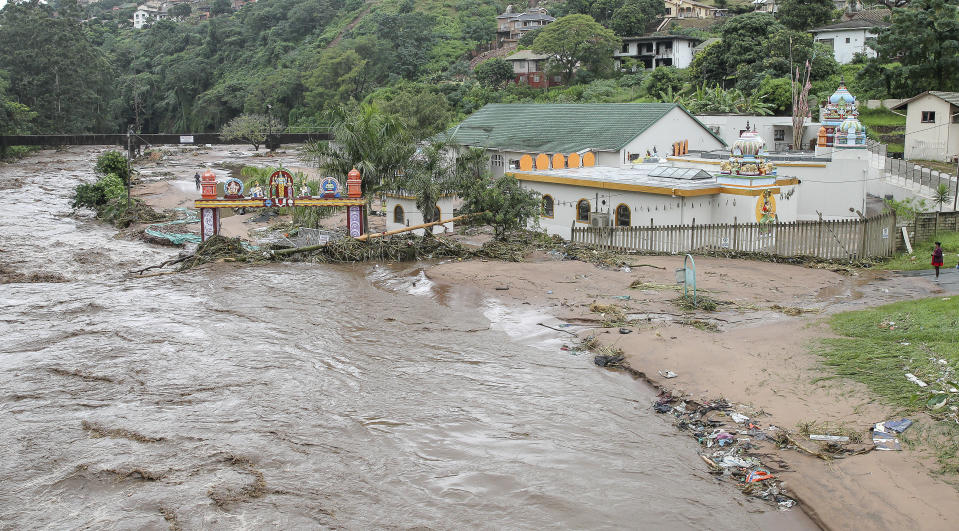 FILE - Floodwaters wash through a property near Durban, South Africa, Tuesday, April 23, 2019. The fatal floods that wreaked havoc in South Africa in mid-April this year have been attributed to climate change, an analysis published Friday, May 13, 2022 by a team of leading climate scientists said.The World Weather Attribution group analyzed both historical and emerging sets of data from the catastrophic rainfall that led to floods which triggered massive landslides in the Eastern Cape and Kwa-Zulu Natal provinces of South Africa. (AP Photo, File)