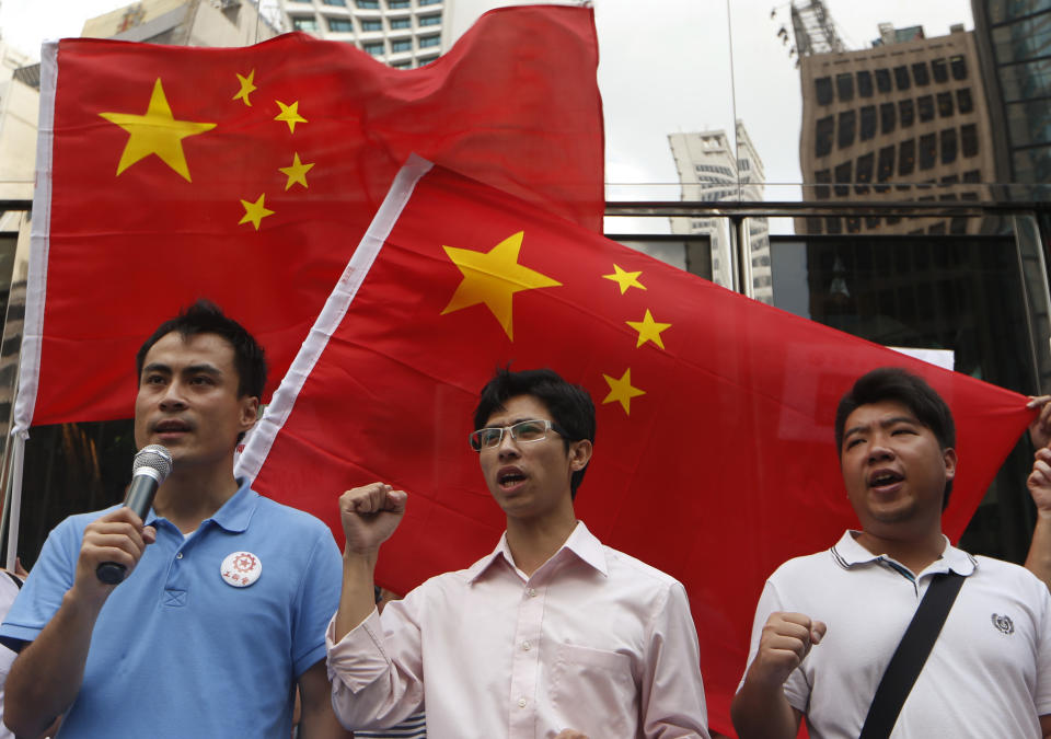 Anti-Japan protesters shout slogans in front of Chinese national flags during a rally outside the Japanese Consulate General in Hong Kong Thursday Aug. 16, 2012 as they demand Japanese government to release Chinese activists arrested in Japan after landing on Uotsuri Island, one of the islands of Senkaku in Japanese and Diaoyu in Chinese. China's official Xinhua News Agency said the arrests of the 14 people, who included Hong Kong residents and mainland Chinese, had caused tensions over its territorial dispute with Japan to surge "to a new high." (AP Photo/Kin Cheung)