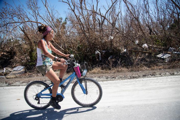 Bridgit Stone-Budd rides her bike on Sanibel Island on Friday, Oct. 7, 2022. Budd, who owns The Pecking Order restaurant, stayed on the island during the storm and has been checking on homes for her friends.
