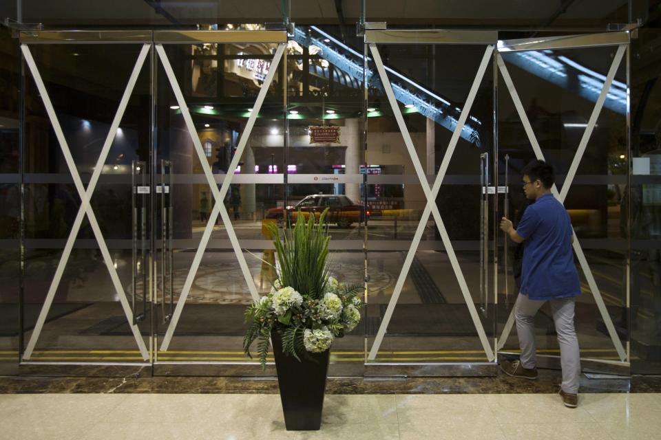 A man leaves a shopping mall, which entrances are taped in anticipation of Typhoon Usagi, in Hong Kong September 21, 2013. Packing winds of 185 kph (114 mph) near the center and gusts of up to 220 kph, Typhoon Usagi on Saturday weakened after hitting the Batanes island group, and is moving slowly west-northwest at 19 kph towards southern China, the weather bureau said. REUTERS/Tyrone Siu (CHINA - Tags: ENVIRONMENT DISASTER BUSINESS)