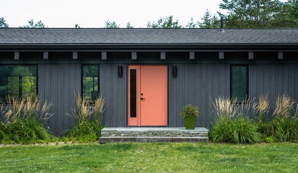 The new exterior was kept dark, but the front door was given a punch of color.