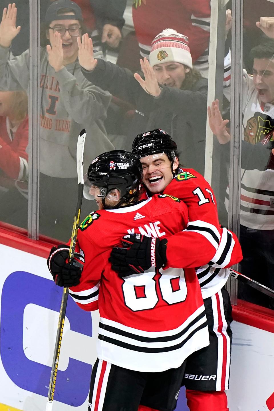 Chicago Blackhawks left wing Alex DeBrincat, right, celebrates with right wing Patrick Kane after scoring the game-winning goal against the St. Louis Blues during an overtime period of an NHL hockey game in Chicago, Friday, Nov. 26, 2021. The Chicago Blackhawks won 3-2 in overtime.(AP Photo/Nam Y. Huh)