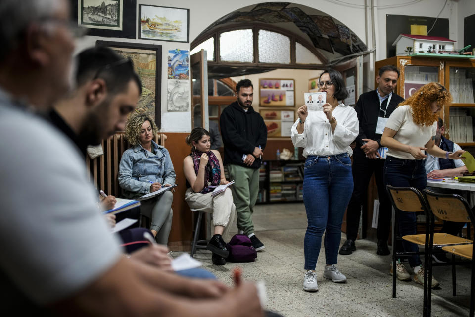 Volunteers, left, look at an election representative showing a ballot during the counting process at a polling station in Istanbul, Turkey, Sunday, May 28, 2023. With local elections across Turkey days away, legal experts are coaching thousands of volunteer election monitors on the rules they'll need to watch for fraud and ensure a fair vote. (AP Photo/Emrah Gurel)