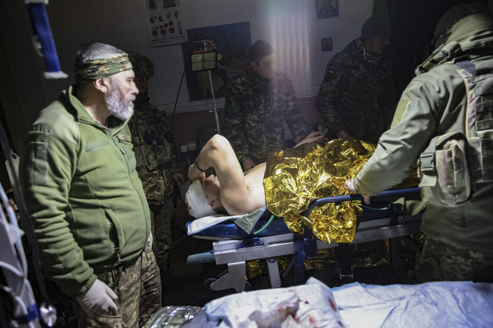 Medics give the first aid to a wounded Ukrainian soldier near Bakhmut, the site of the heaviest battles with the Russian troops, Donetsk region, Ukraine, Monday, Feb. 27, 2023. (AP Photo/Yevhen Titov)