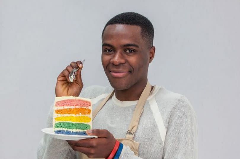 Liam Charles with a rainbow cake