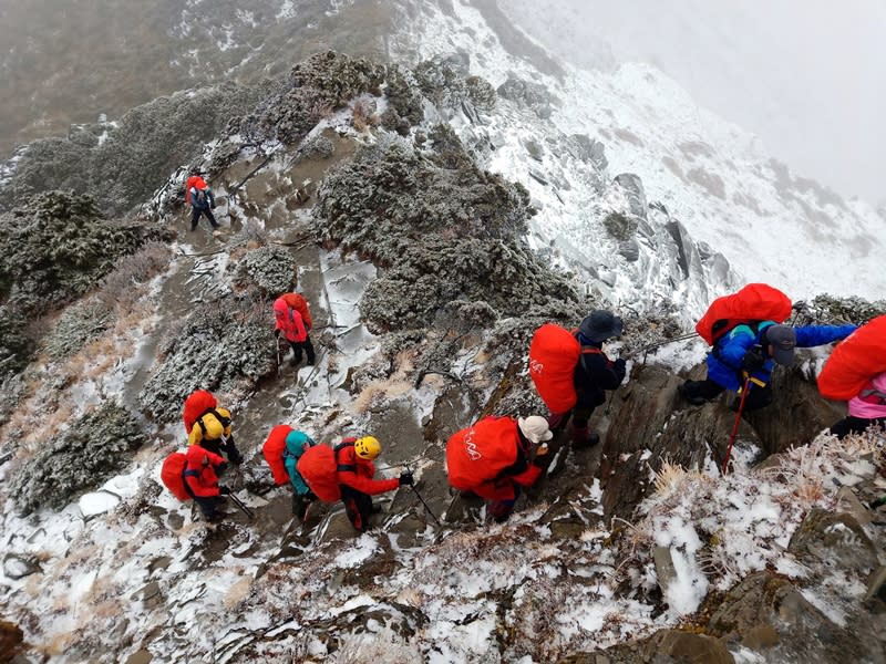 南湖大山6日上午降下入冬第一場雪，讓山友相當驚喜，但因持續飄雪，基於安全考量，山友選擇暫時下撤到山屋。（林心聖提供） 