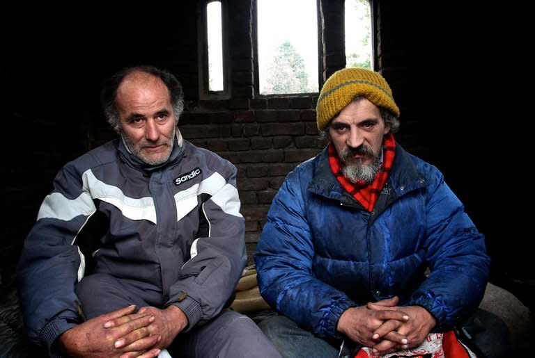 Homeless men Bratislav Jovanovic (R), 43, and Aleksandar Dejic, 50, sit on January 10, 2013 inside a tomb at a cemetery in Nis, Serbia. Both men have been homeless for nearly twenty years, since they lost their family members