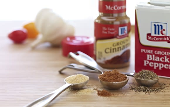 McCormick cinnamon and pepper bottles next to measuring spoons filled with spices