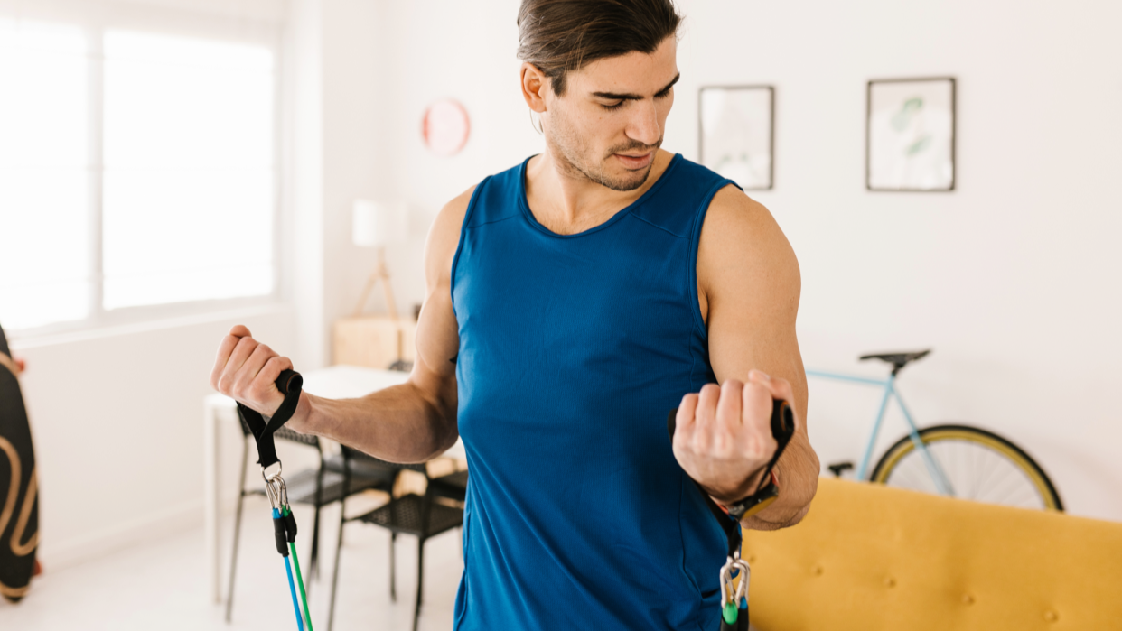  Man doing resistance band bicep curls. 