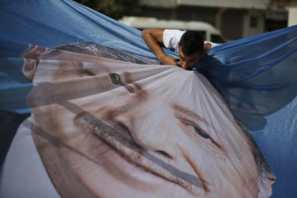 A man kisses a banner showing Turkey's President Recep Tayyip Erdogan during show of support by about a dozen people for Turkey's operation in Syria, in the border town of Akcakale, Sanliurfa province, southeastern Turkey, on Oct. 14, 2019. Erdogan has criticized NATO allies which are looking to broaden an arms embargo against Turkey over its push into northern Syria.  (Photo: Lefteris Pitarakis/AP)