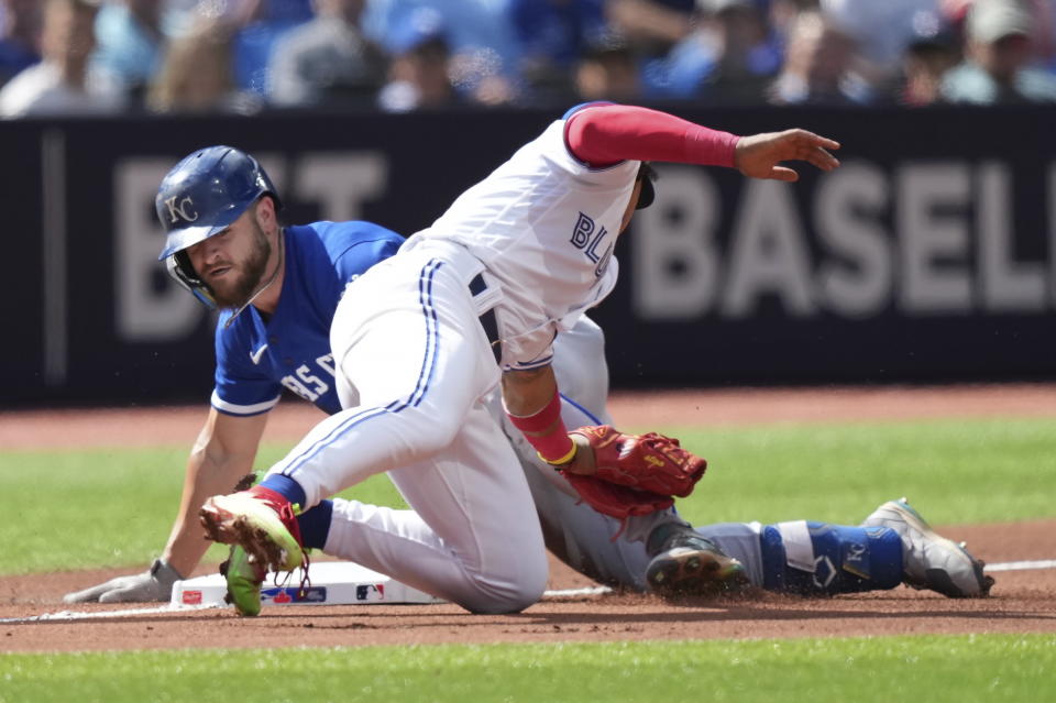 Kansas City Royals center fielder Kyle Isbel slides into third base with a triple past the tag of Toronto Blue Jays third baseman Santiago Espinal during the sixth inning of a baseball game in Toronto on Sunday, Sept. 10, 2023. (Nathan Denette/The Canadian Press via AP)