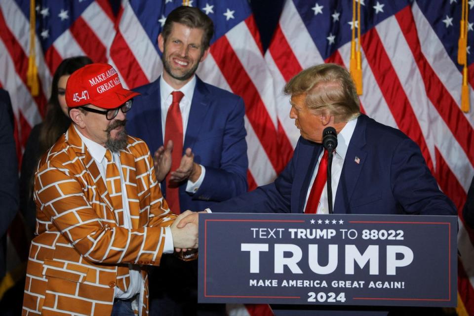 Trump invited a man dressed in a wall-patterned jacket and tie onto the stage (REUTERS)