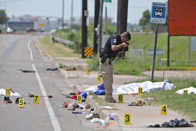 A law enforcement officer photographs the scene after a deadly incident 