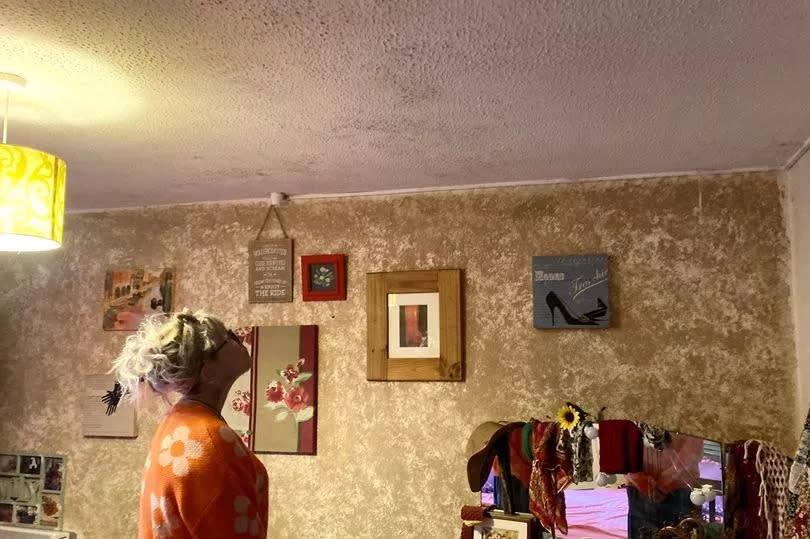 Liz Pannell in her bedroom which has mould on the ceiling