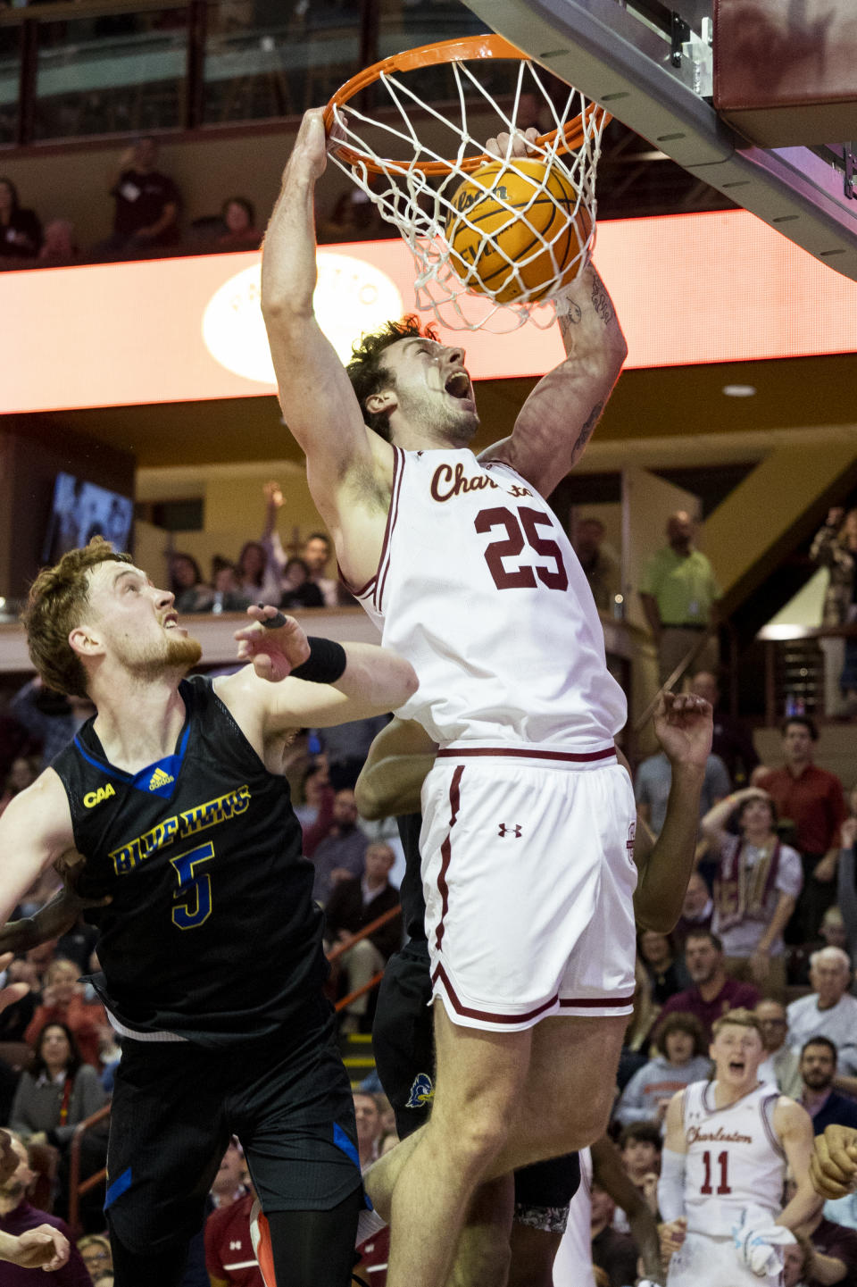 College of Charleston's Ben Burnham (25) dunks after a missed shot over Delaware's Ray Christian (5) late in the second half that helped secure Charleston's 75-64 victory during a NCAA college basketball game in Charleston, S.C., Saturday, Jan. 7, 2023. (AP Photo/Mic Smith)