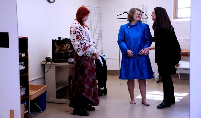 From a reflection in a mirror, Mount Mary University President Isabelle Cherney, center, enjoys a light moment while being fitted for her silk dupioni sheath dress and jacket with crystal buttons with designer Gigi Wagener, right, while assistant professor Elena Pitts watches the fitting. Cherney will wear the dress for a Mass and inauguration on March 31.