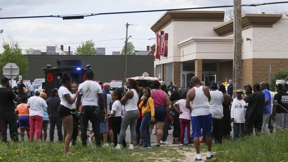 A crowd gathers as police investigate after a shooting at a supermarket on Saturday, May 14, 2022, in Buffalo, N.Y. Multiple people were shot  at the Tops Friendly Market.  Police have notified the public that the alleged shooter was in custody. (AP Photo/Joshua Bessex)