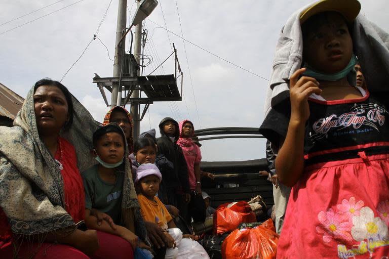 This picture taken on November 11, 2013 shows villagers taking a military truck as they flee their homes to a shelter, at the Guru Kinayan village in Karo